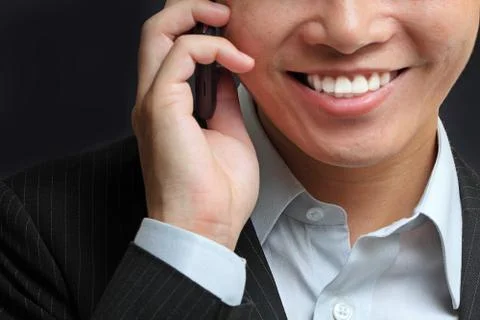 Portrait of e young man talking on mobile against a black background Stock Photos