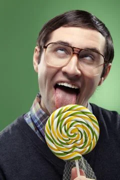 Portrait of ecstatic nerd boy sucking a lollipop Stock Photos