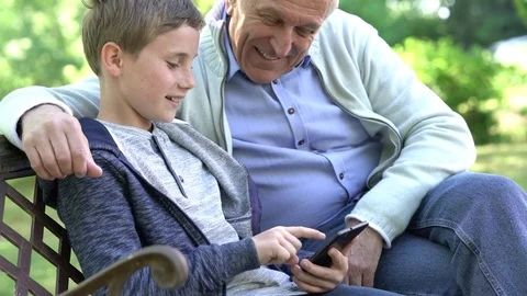 Portrait of ederly man with grandkid using smartphone Stock-Footage 75512012