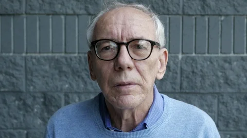 Portrait of an elderly balding man with glasses looking into camera. Stock Footage 106132536