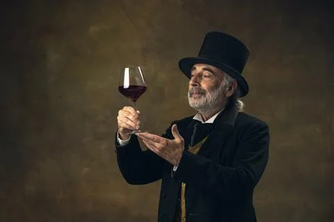 Portrait of elderly gray-haired man, gentleman, aristocrat or actor tasting wine Stock Photos
