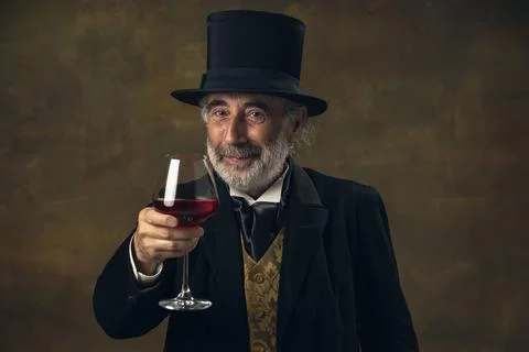 Portrait of elderly gray-haired man, gentleman, aristocrat or actor tasting wine Stock Photos