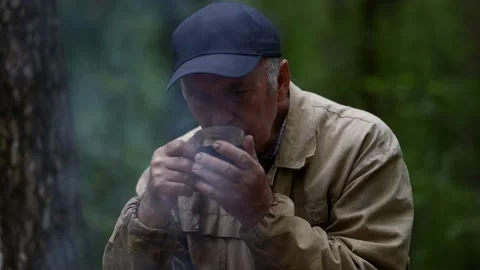 Portrait of an elderly man in a cap. he sits thoughtfully in the forest and Stock Footage 163662018