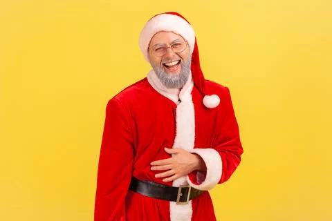 Portrait of elderly man with gray beard wearing santa claus costume holding his Stock-Fotos