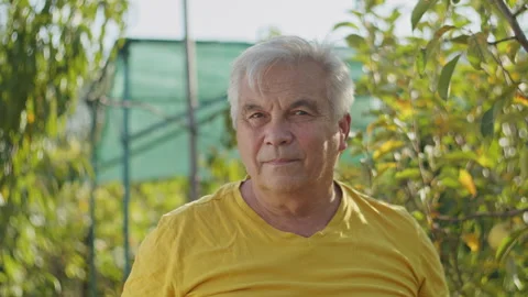 Portrait of elderly man in orchard with soft focus background. Lifestyle Stock Footage 274884439