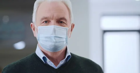 Portrait elderly man in protective mask looking at camera smiling in hospital Video stock 151801467