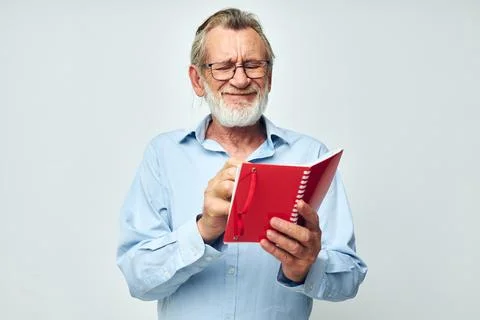 Portrait elderly man with red notebook and pen light background Stock Photos