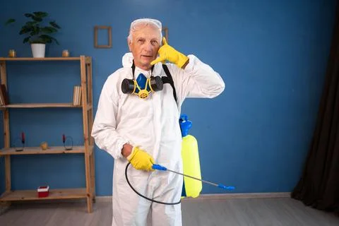 Portrait of Elderly pest control worker killing insects inside infested hou.. Stock Photos
