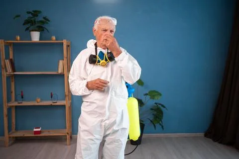 Portrait of Elderly pest control worker covering nose in disgust gesture insi Stock Photos
