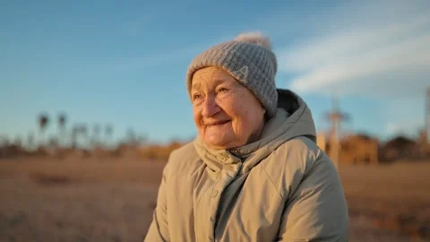 Portrait of elderly woman in warm light, thoughtful look, slow motion Stock Footage 328097053
