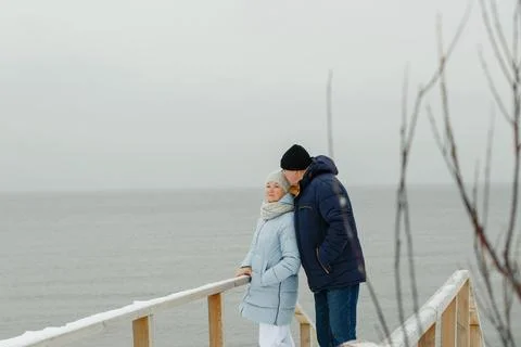 Portrait of an elegant elderly couple on a winter snowy day by the sea Stock Photos