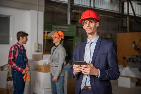 Portrait of an elegant engineer with protective helmet and tablet inside th.. Stock-Fotos