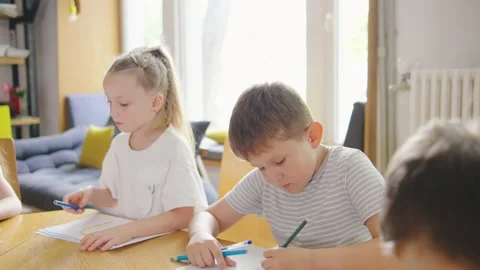 A portrait of an elementary school boy and girl deeply focused on their drawings Stock Footage 284266896