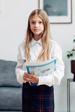 Portrait of an elementary school student standing at home with a book Stock Photos