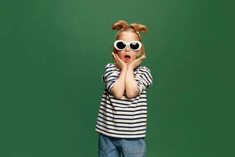 Portrait of emotiona, beautufl little girl, childin striped shirt and sunglasses Stock Photos