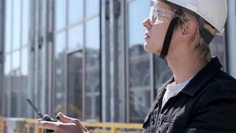 Portrait of engineer construction worker in helmet controlling flying drone Video stock 106207265