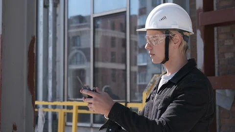 Portrait of engineer construction worker in helmet controlling flying drone Stock Footage 106235969
