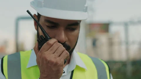 Portrait of engineer giving instructions via portable radio at construction site Stock Footage 305761352