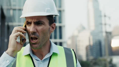 Portrait of engineer in hardhat speaking angrily on phone Stock Footage 304705388