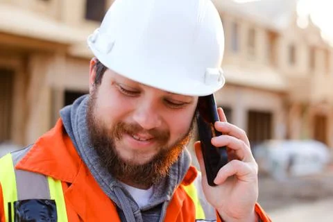 Portrait of engineer talking by smartphone on construction site. Foto stock