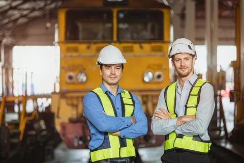 Portrait engineer two men standing in locomotive train depot friend technic.. Foto stock