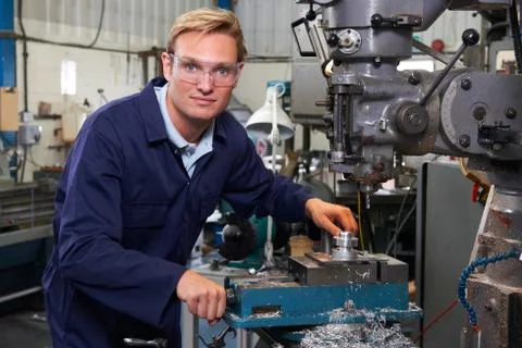 Portrait Of Engineer Using Drill In Factory Stock Photos