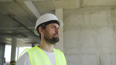 Portrait of Engineer in a white helmet and yellow vest inspecting a construction Vídeo Stock 348239571