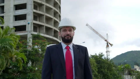 Portrait of an Engineer in a white protective helmet in a business suit against Stock Footage 163229276