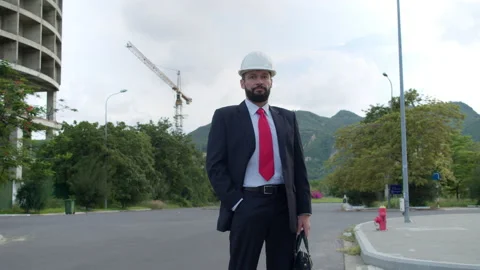 Portrait of an engineer in white protective helmet in a business suit with red Stock Footage 163229314