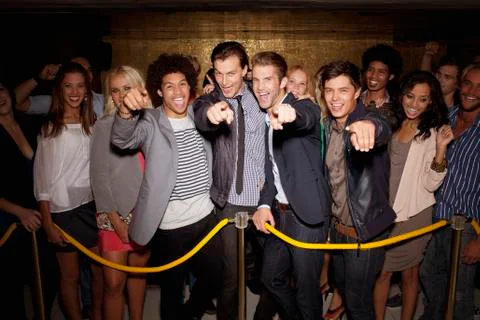 Portrait of enthusiastic crowd waiting in queue outside night club Stock Photos