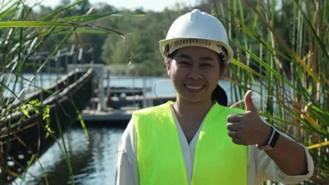 Portrait of environmental engineer wearing white helmet working at reservoir. Stock Footage 229708631
