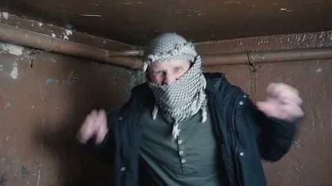 Portrait of an evil comic terrorist. mujahid in a scarf wants to scare you 動画素材 82500569
