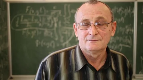 Portrait of face of elderly man in glasses near blackboard with formula. Stock Footage 69988986
