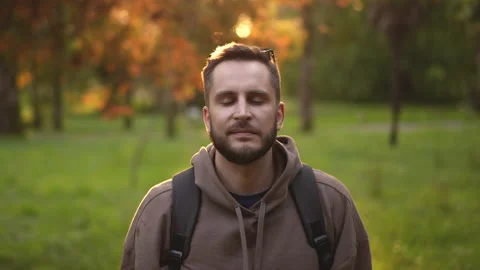 Portrait face of looking at camera bearded traveler with backpack on hiking trip Stock Footage 163843460