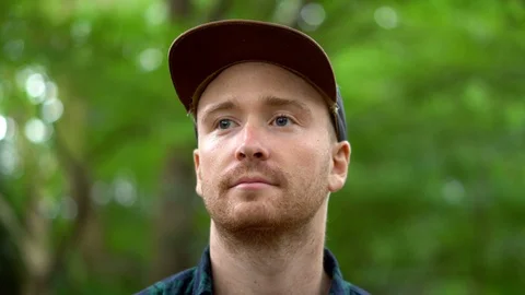 Portrait Face Tracking Shot of Caucasian Man Walking With Nature Background Stock Footage 105058960