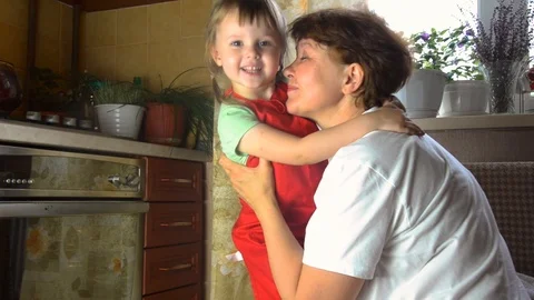 Portrait of faces, hands happy granny hug granddaughter. toddler girl play with Stock Footage 111486906
