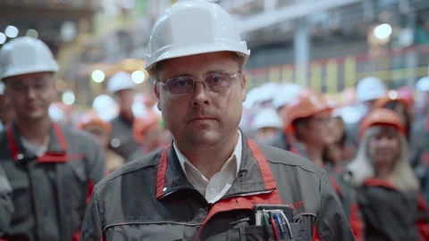 Portrait of a factory worker in front of a crowd of workers. Stock Footage 196174276