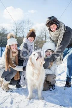 Portrait Of Family With Dog On A Beautiful Snowy Day