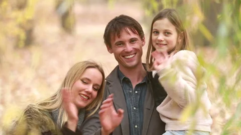 Portrait of family smiling and waving in park Stock Footage 59554433
