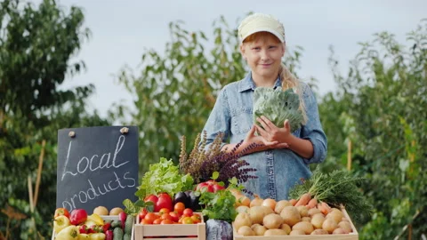 Portrait of farmer child with cabbage in hands behind farmer's market counter Stock Footage 158687326