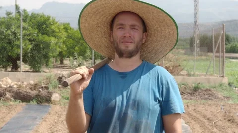 Portrait of a farmer man with a hoe looking at the camera. Organic farming Stock Footage 157487534