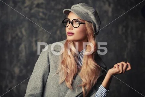 A portrait of a fashionable bright lady posing in studio over grunge backgrou Stock Photos
