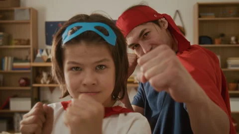 Portrait of Father and Son Playing Superheroes and Punching at Camera Stock Footage 336176826