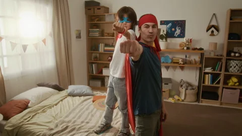 Portrait of Father with Son Posing as Superheroes Punching Towards Camera Stock Footage 336188502