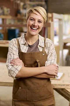 Portrait Of Female Apprentice Working As Carpenter In Furniture Workshop 스톡 사진