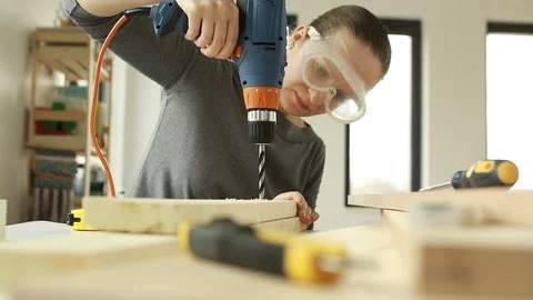 Portrait of   female carpenter using drill machine on wood. Stock Footage 106397156