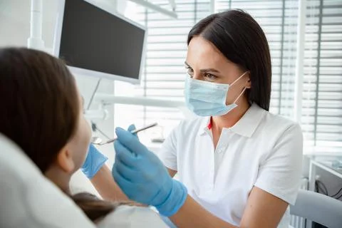Portrait of female doctor using instruments during procedure in hospital Stock Photos