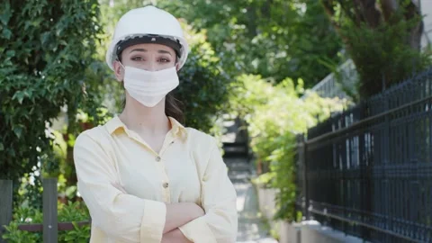 Portrait of female engineer smiling at the camera with helmet and medical mask. Stock Footage 135991733
