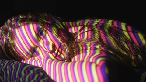 Portrait of female face. Projected line pattern in pink, purple &amp; yellow. Stock Footage 89659941