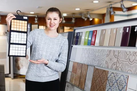 Portrait of female looking sample of ceramic tile in shop Stock Photos
